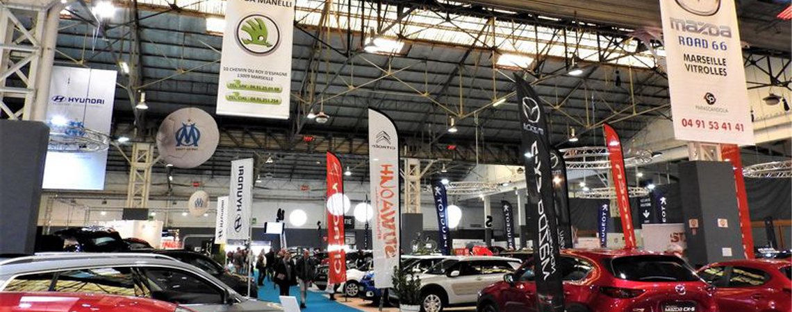 Salon automobile, structures aérienne et drapeaux à effigie des marques.